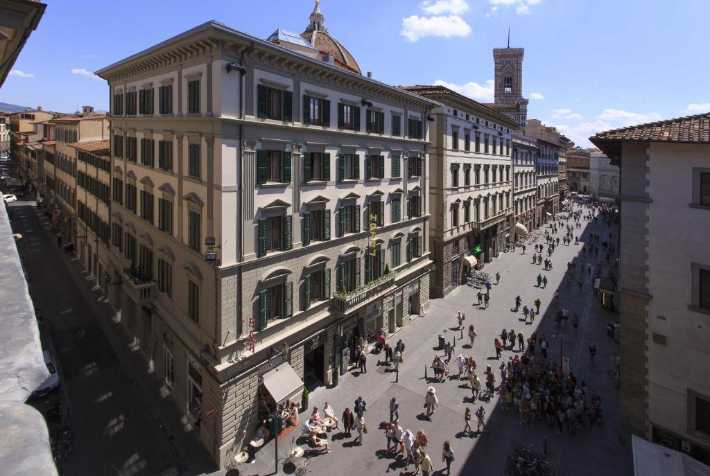 佛罗伦萨斯帕戴酒店的一群人沿着大楼旁边的街道走着