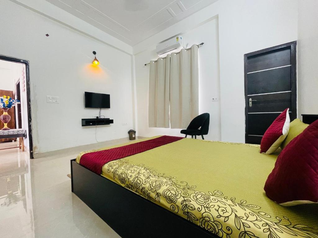 勒克瑙Atulyam Stays Sushant Golf City的一间卧室配有一张大床和电视