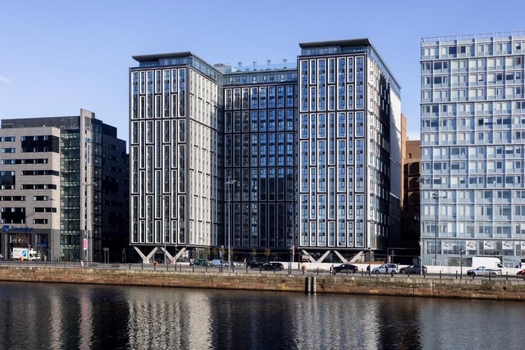 利物浦Premium Apartments at Copper House in Liverpool City Centre的河边一座城市的三座高楼