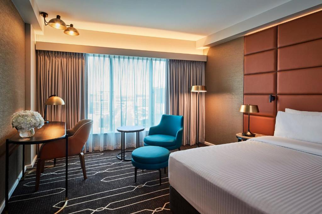 悉尼悉尼机场假日酒店的酒店客房,配有一张床、一张桌子和椅子