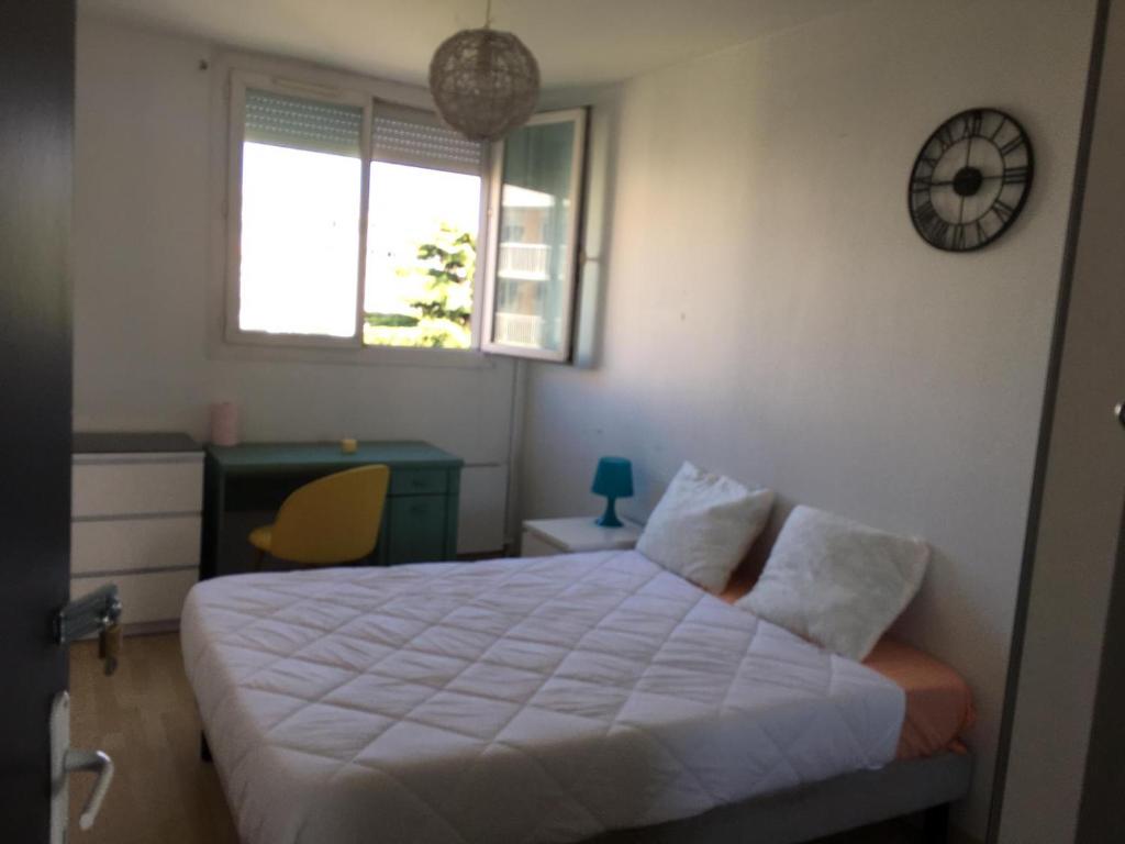 希利马扎兰KP Home的一间卧室配有一张床、一张桌子和闹钟