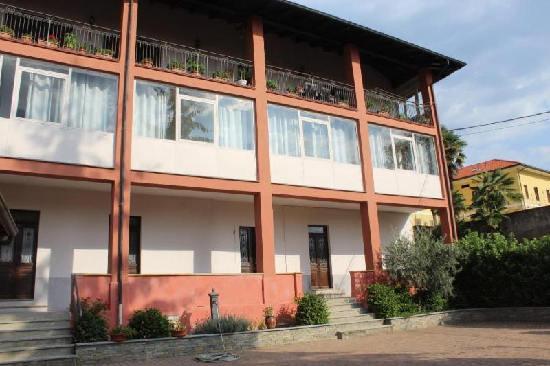 Baraggia di BocaIL VECCHIO CAMINO的一座大型的红色和白色建筑,设有阳台
