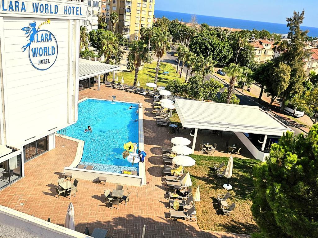 安塔利亚拉瑞世界酒店的享有带椅子和遮阳伞的游泳池的上方景色