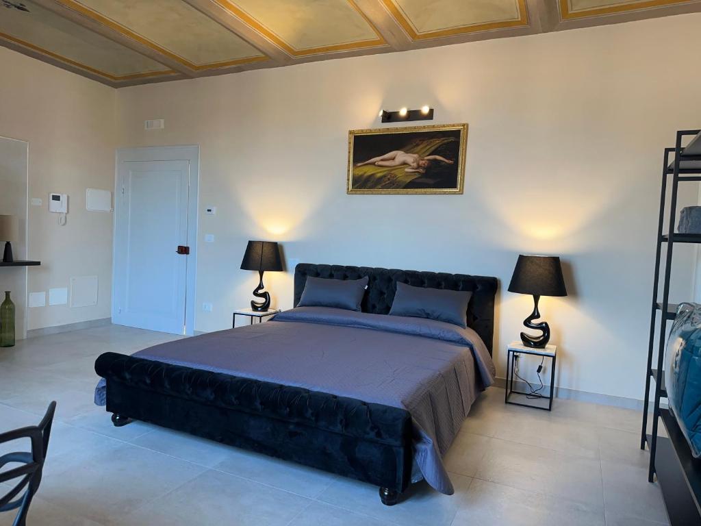 拉奎拉Casa Colonna - Suite della Torre的一间卧室配有一张大床和两盏灯。