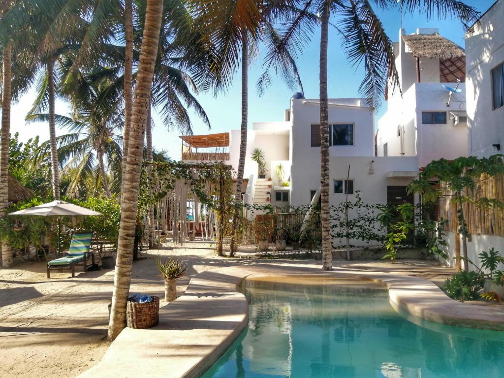 埃尔库约Hotel Boutique Can Cocal El Cuyo的棕榈树屋前的游泳池