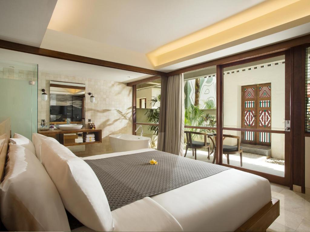 库塔库塔阿姆纳雅酒店的一间带大床的卧室和一个阳台
