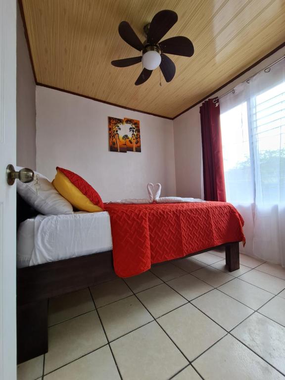 福尔图纳Cabins Guayabon #2, Arenal Volcano La Fortuna的一间卧室配有一张床和吊扇