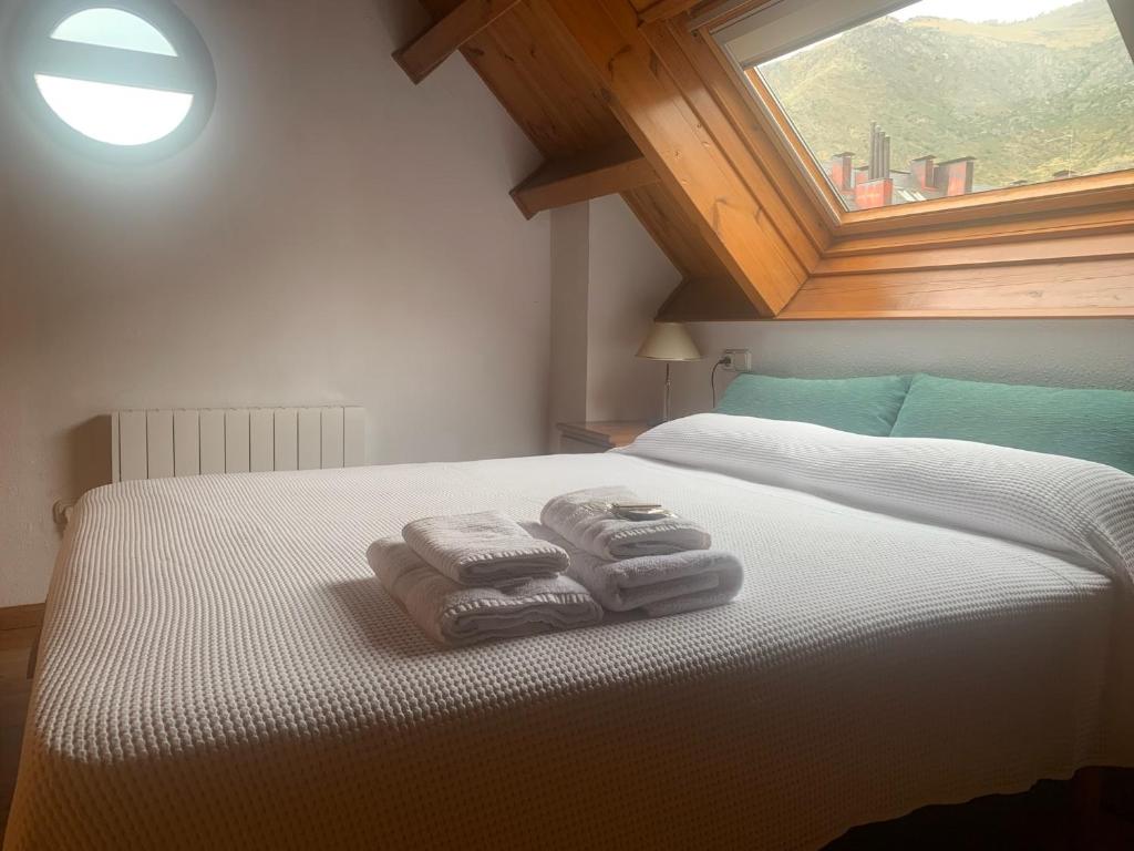 普拉德埃米塔Allotjament SV的卧室配有带2条毛巾的窗户,位于床上
