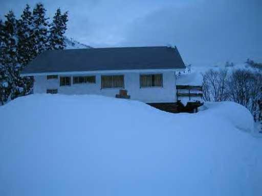 关市STI SKI LODGE的白房子,地面上积雪