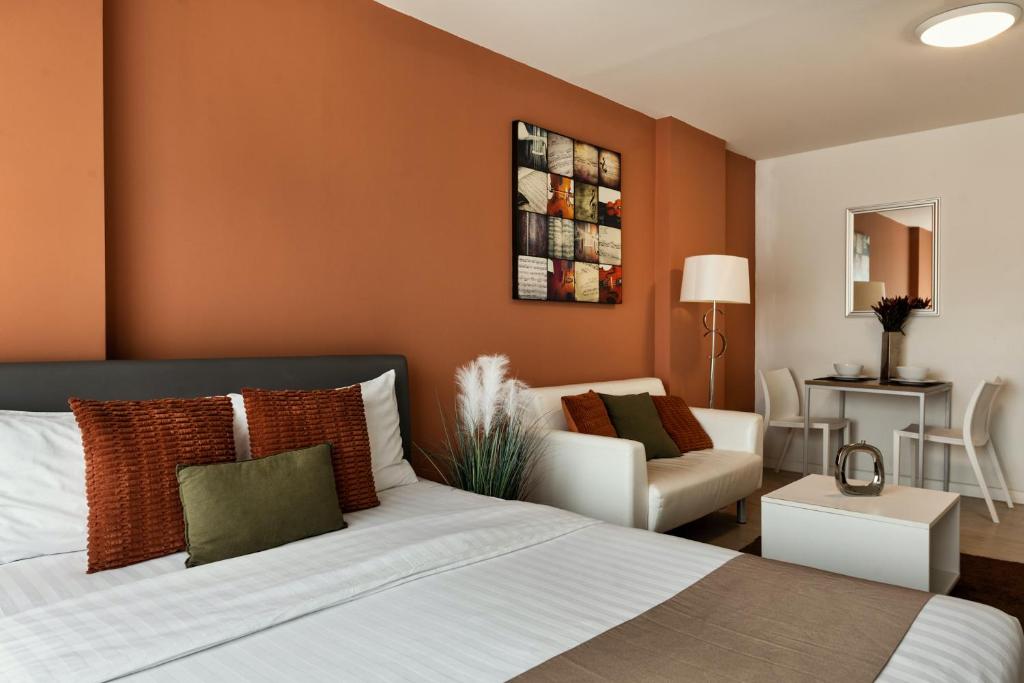 华欣First Choice Suites by the Sea SHA Plus Extra的一间卧室设有一张床和一间客厅。