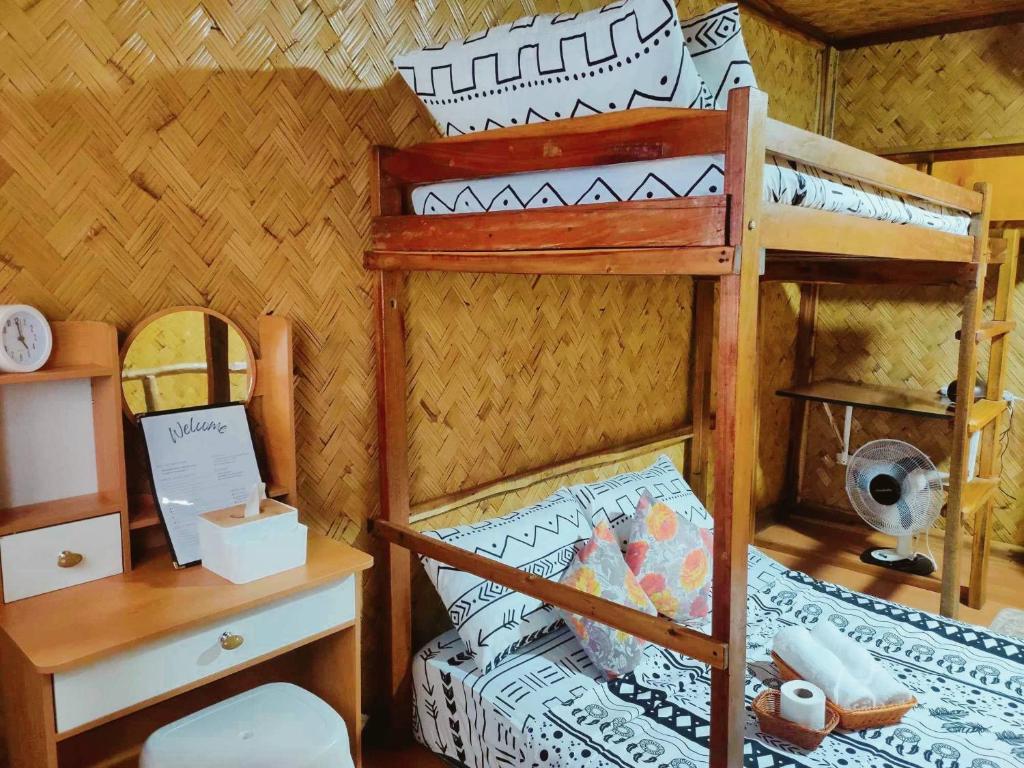 爱妮岛El Nido Backpackers Guesthouse的一间卧室配有一张双层床、一张桌子和一张床