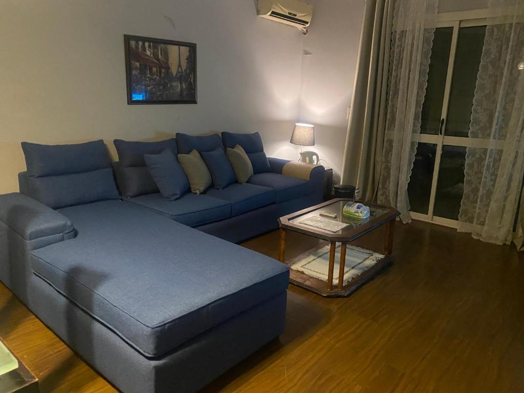 十月六日城A cosy Apartment just for you to relax的客厅配有蓝色的沙发和桌子
