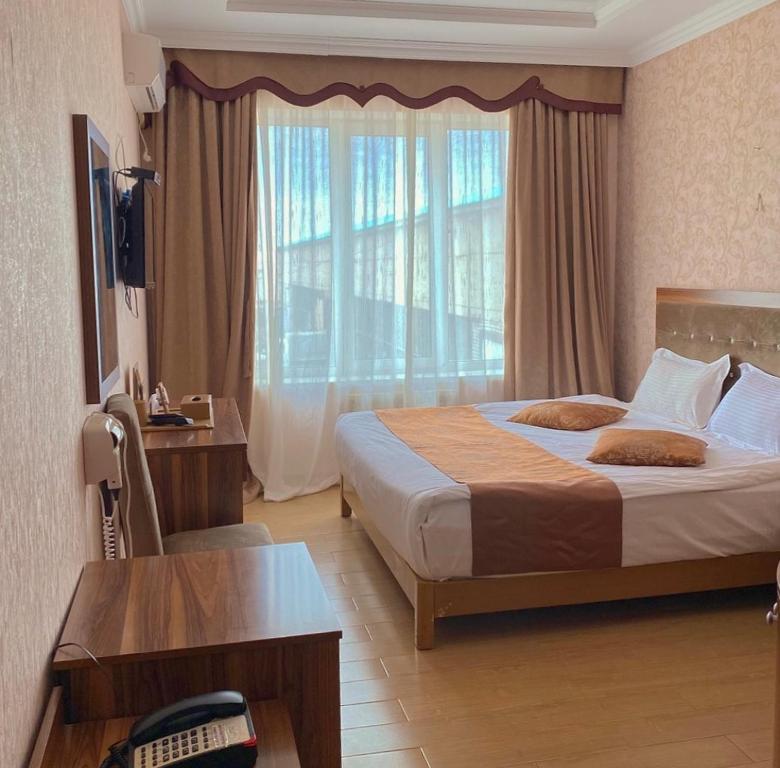 阿克托比Royal_hotel_hostel的酒店客房设有一张床和一个大窗户