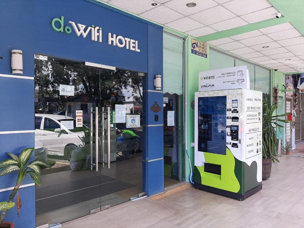 双溪大年Dowifi Hotel -Self Service Kiosk的车前有车间门的商店