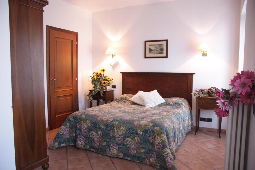 斯特雷萨拉罗卡达酒店的配有床和鲜花桌的酒店客房