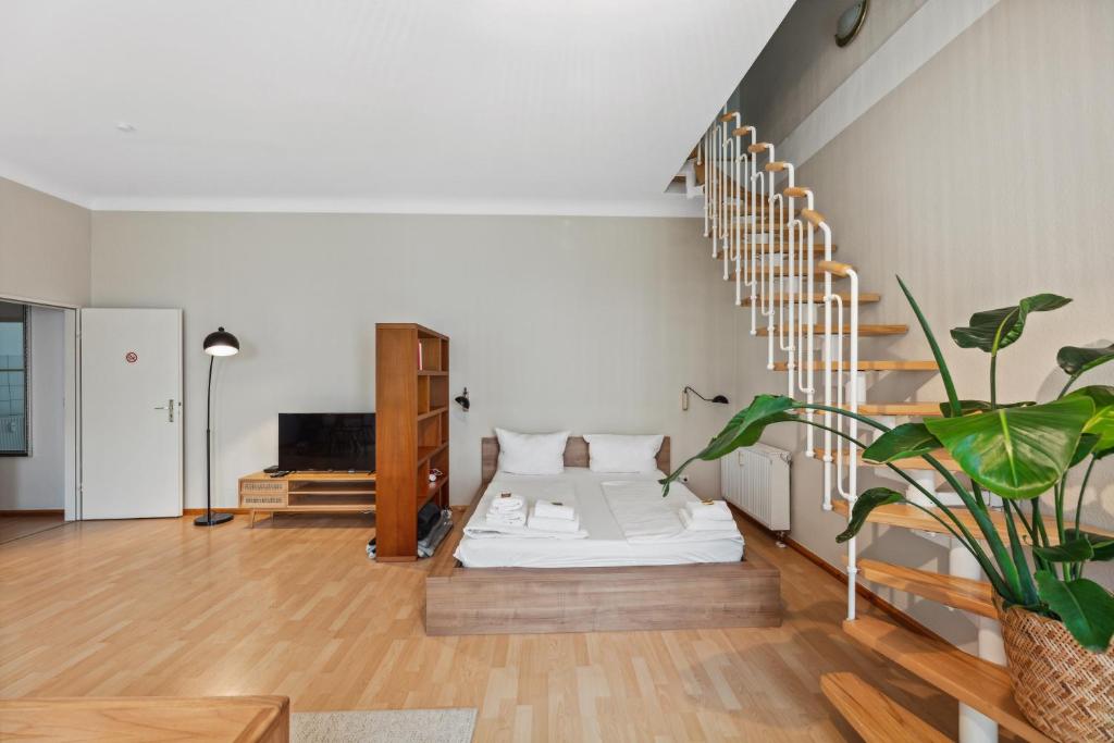 柏林Arbio I 1A Rooms & Apartments Prenzlauerberg Berlin的一间带床和楼梯的客厅