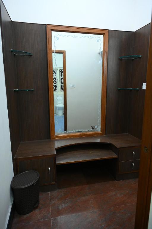 哈桑Amayaa Courtyard Homestay的一间带镜子和木制橱柜的浴室