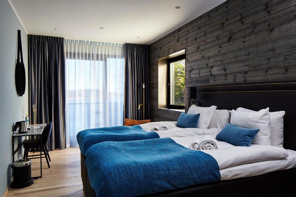 诺尔泰利耶马尔霍门酒店的一间卧室配有两张带蓝色枕头的床