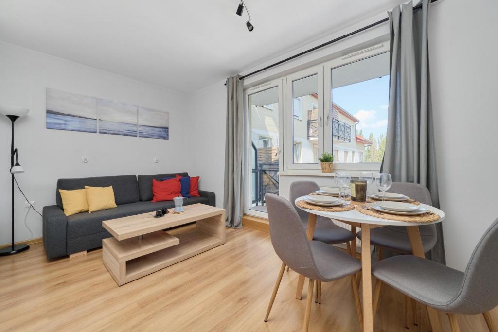 弗罗茨瓦夫Peaceful Wrocław Apartment for 4 Guests with Balcony by Renters的客厅配有桌子和沙发