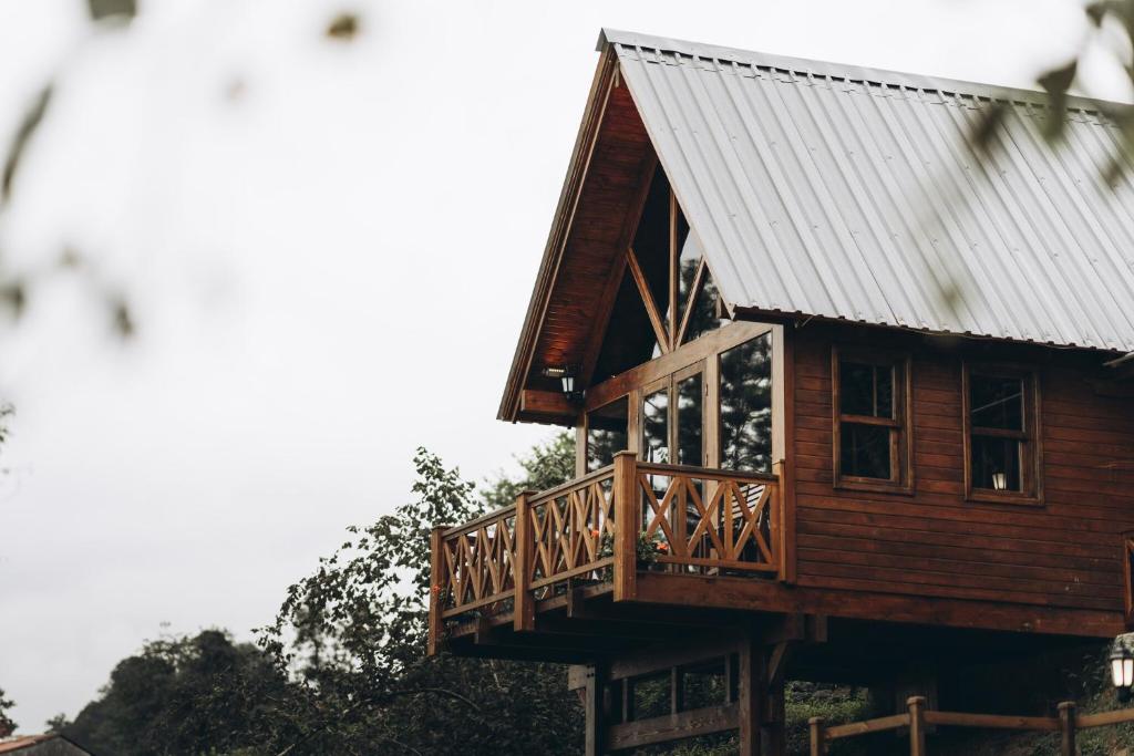 阿尔特温Lome Çiftliği Otel ve Restoran的小木屋设有阳台和金属屋顶