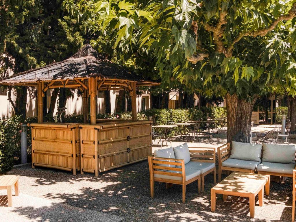 阿维尼翁南阿维农宜必思尚品酒店的一个带椅子和桌子的木制凉亭