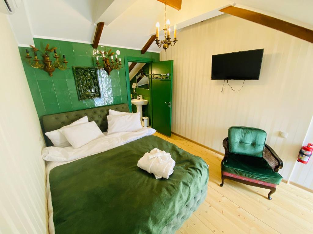 姆茨赫塔Tatin - Hotel & Café in Mtskheta的一间卧室配有绿色的床和绿色椅子