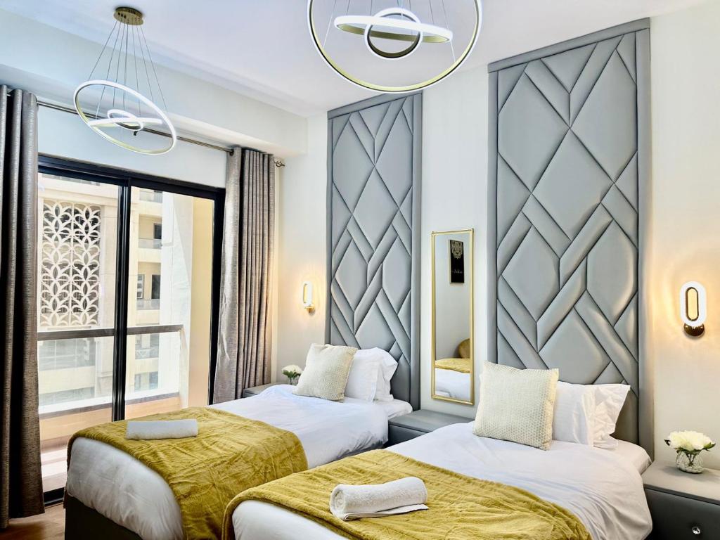 迪拜2BR Luxury Apartment Marina View的酒店客房设有两张床和窗户。