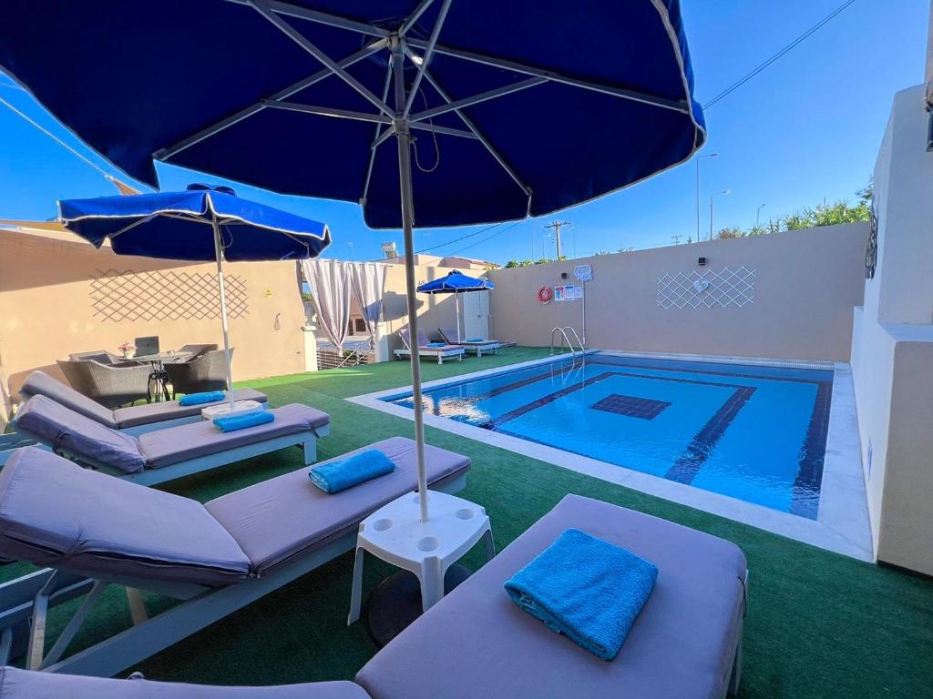 阿凡杜Villa Nektarina的游泳池旁的游泳池配有椅子和遮阳伞
