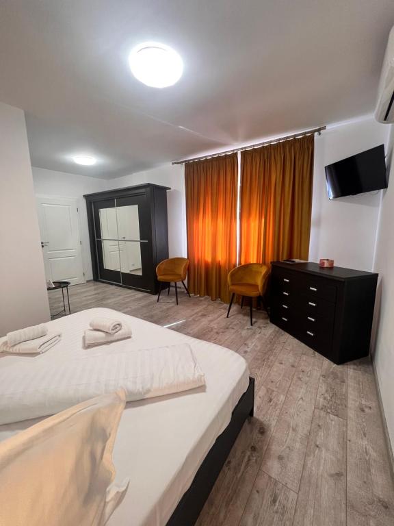 NiculiţelAgropensiunea Vila Cristina的一间卧室配有一张床、梳妆台和电视。