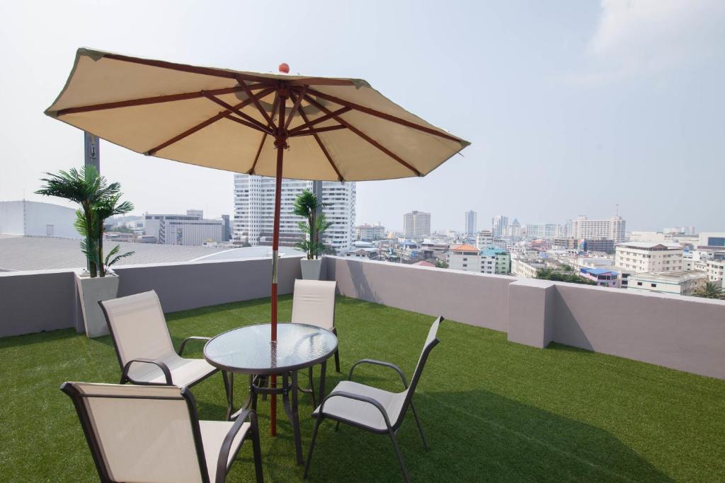 是拉差拉查公寓式酒店的屋顶上配有遮阳伞的桌椅