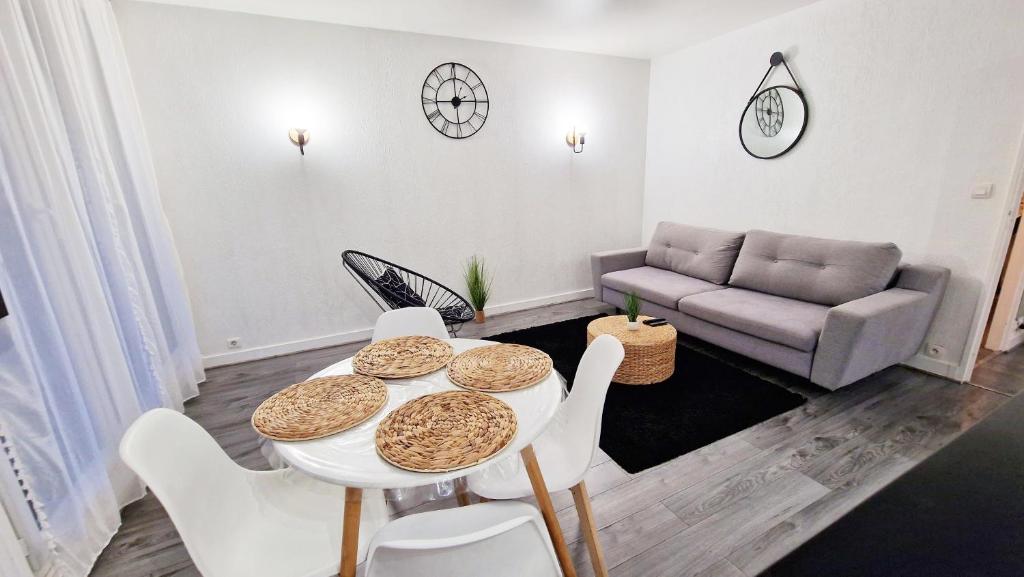 希利马扎兰Appartement moderne cosy et Calme - 15 min Paris的客厅配有桌椅和沙发
