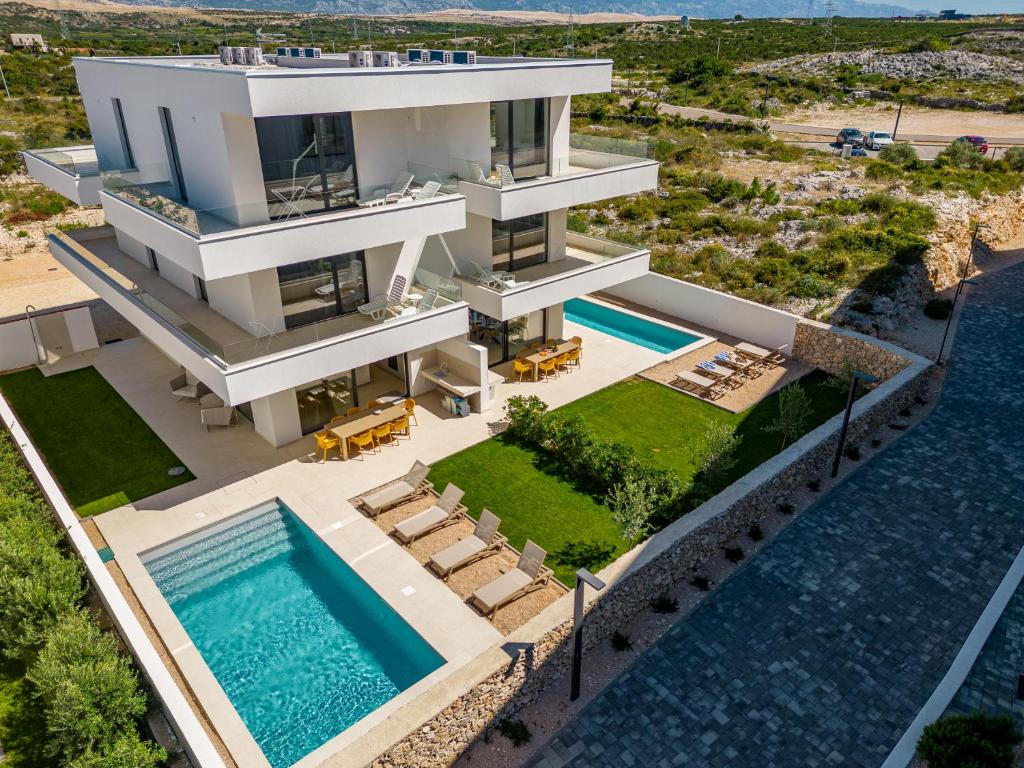 诺瓦利娅Villa Arenisca Novalja的享有带游泳池的房屋的空中景致