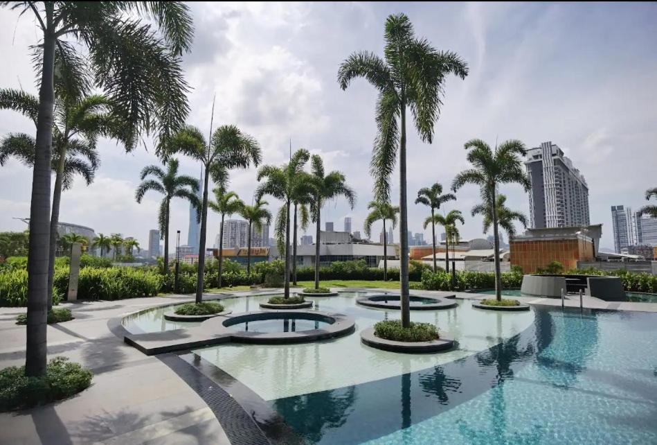 吉隆坡TRION KL by JRLodge Homestay的一座种植了棕榈树的大型游泳池