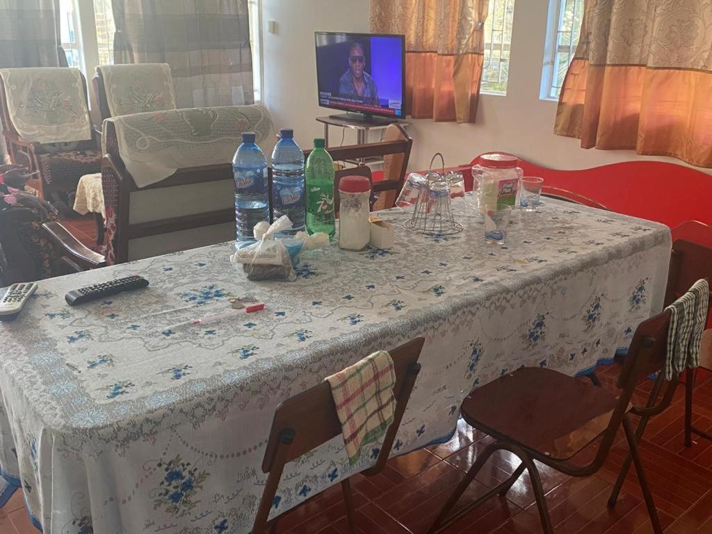 RéunionModern guesthouse的一张桌子,上面有白色的桌布和瓶装水