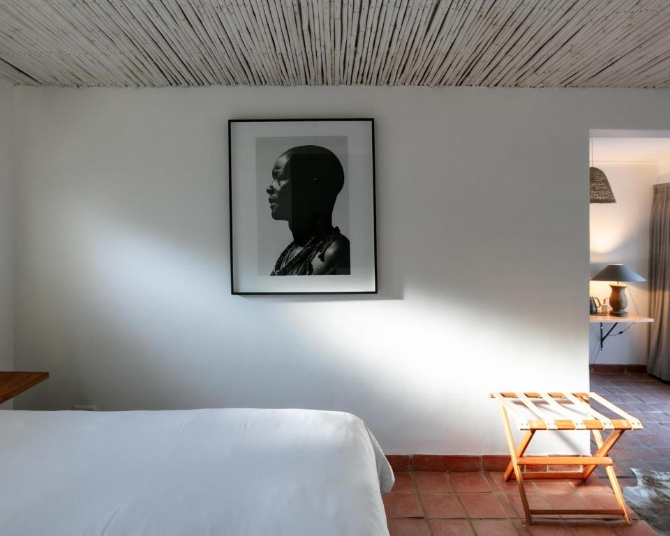 豪特湾MooiBaai的一间设有一张床的客房,墙上挂着一张照片