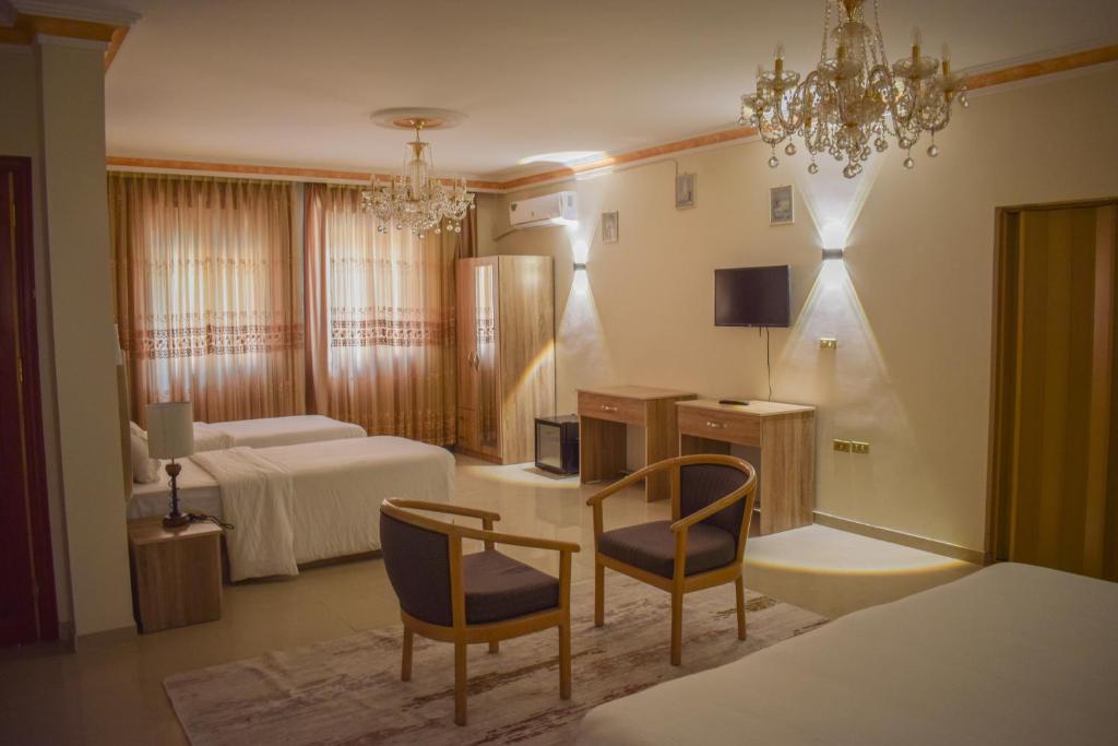 瓦迪穆萨Twilight Hotel Petra的酒店客房设有一间带一张床和两把椅子的卧室