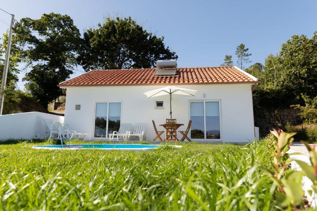 塞洛里库迪巴什图Refugio das Vinhas的一座白色的小房子,在院子里设有一个游泳池