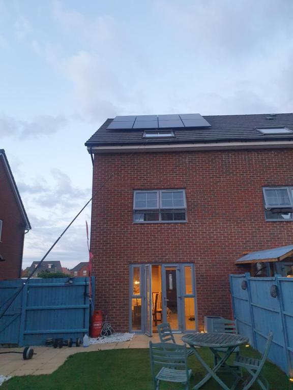 Burton House的屋顶上设有太阳能电池板的砖屋
