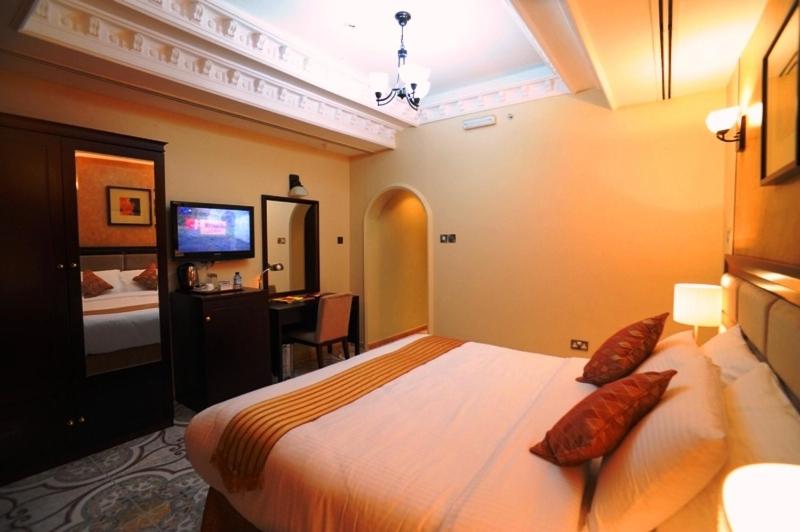 阿布扎比皇家半岛酒店的一间卧室配有一张大床和电视