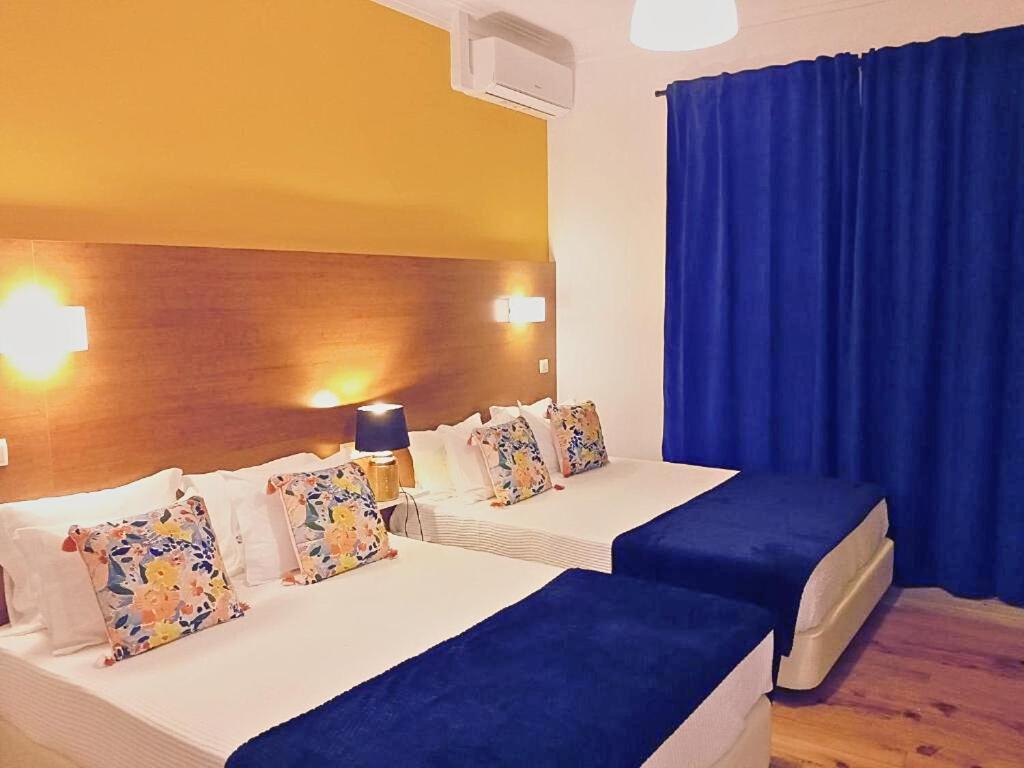 卡尔德拉斯Corredoura Garden的两张位于酒店客房的床,配有蓝色窗帘