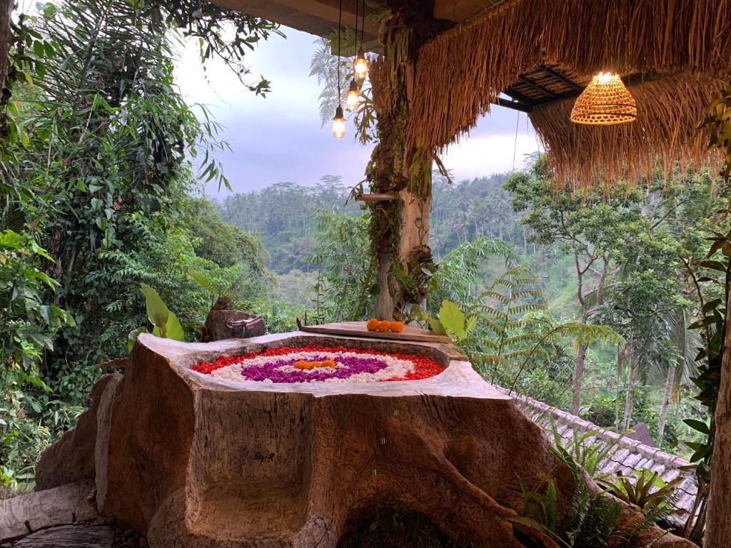 TampaksiringBali Inang Jungle View的一间房间,桌子上摆放着鲜花