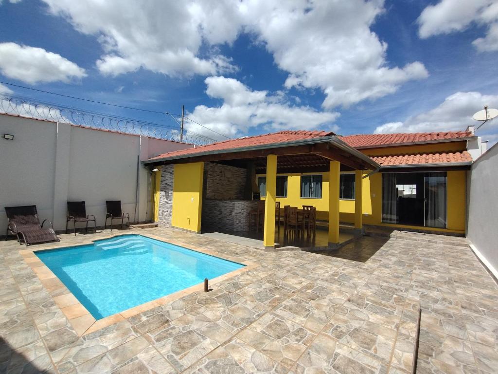 圣若昂-巴蒂斯塔-杜格罗里亚Pouso Oliveira Casa com ar condicionado的庭院中带游泳池的房子
