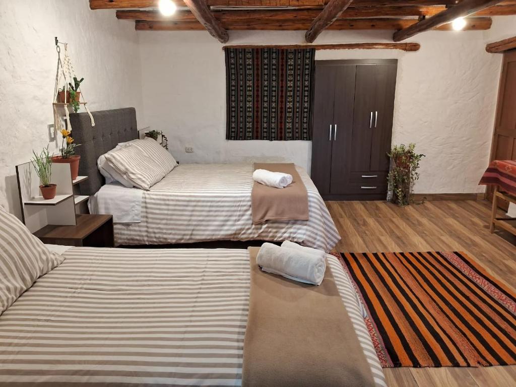 库斯科KOSKO Casa Hotel的一间卧室配有两张床和一个带门的衣柜。