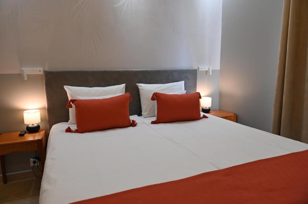 索瓦塔H49 Jacuzzi Penthouse-Adults only的一间卧室配有一张带两个红色枕头的床