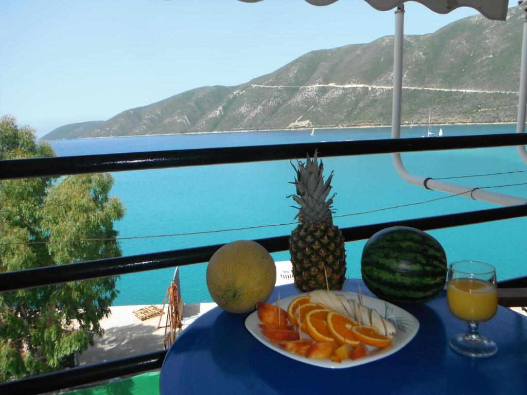 瓦西利基奥尔费斯旅馆的一张桌子,上面放着一盘水果和一杯橙汁