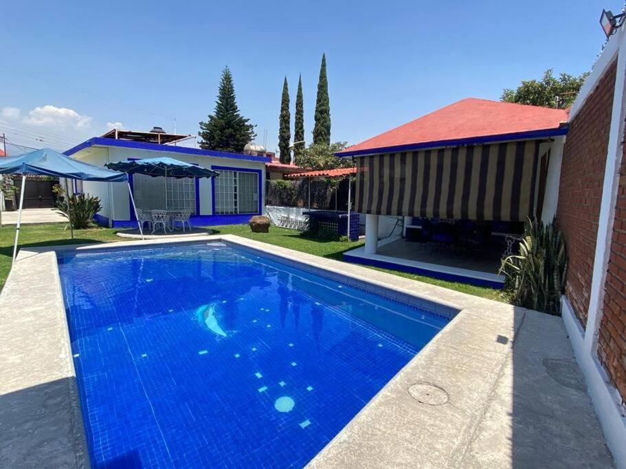 瓦兹特佩克Casa en Oaxtepec的一座带房子的庭院中的蓝色游泳池