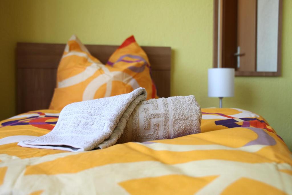 罗斯托克安德威夫特膳食公寓酒店的床上配有色彩缤纷的毯子和枕头