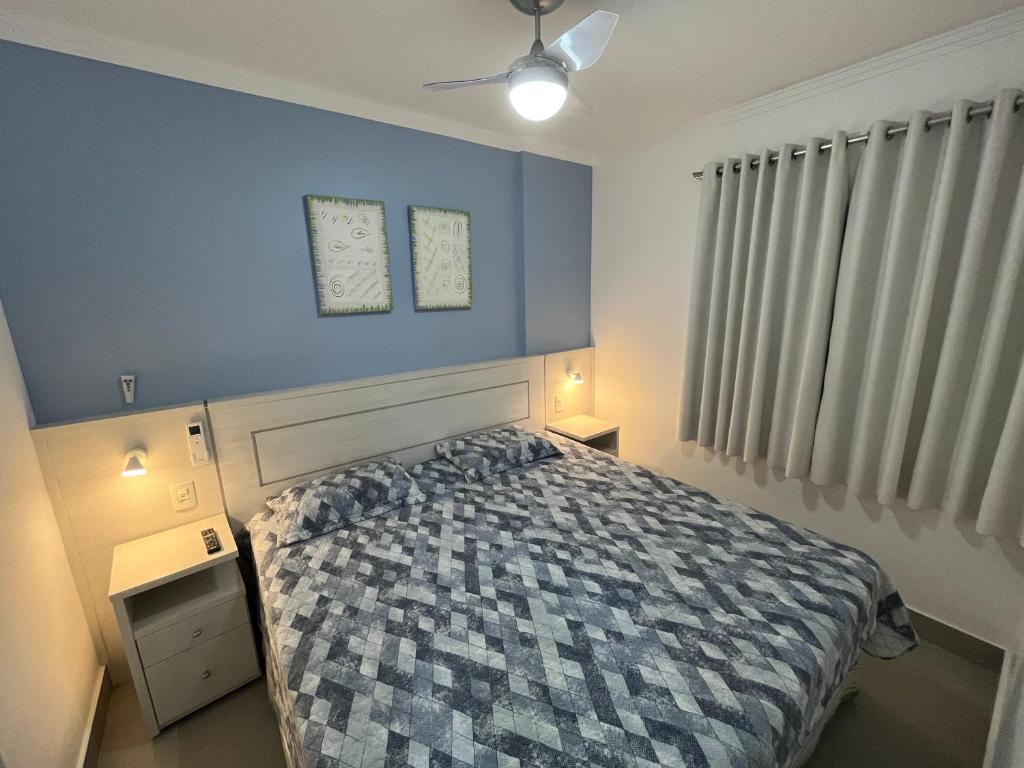 圣劳伦斯海滨FLAT RIVIERA COM VISTA MAR A 150m DA PRAIA !的一间卧室设有一张床和蓝色的墙壁