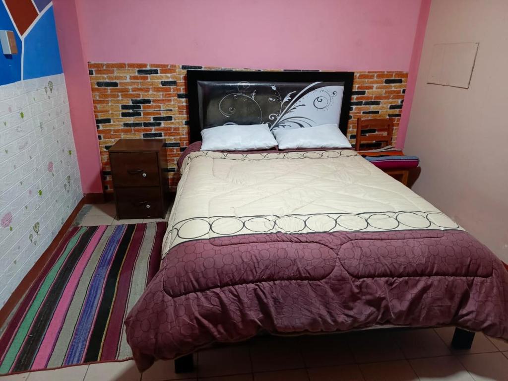 奥鲁罗Backpacker hostal oruro的一间卧室配有一张大床和床头板