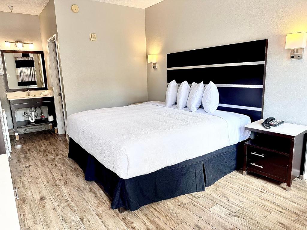 阿林顿Americas Best Value Inn Arlington的酒店客房配有一张带白色床单和枕头的大床。
